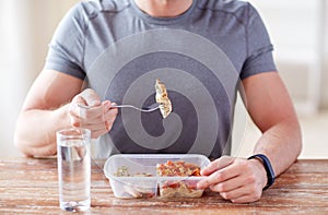 Close up of man with fork and water eating food