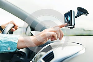 Close up of man with gadget on screen driving car