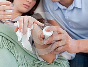 Close-up of a man giving pills to his sick wife