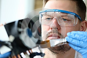 Close-up man goggles mends mechanical part device