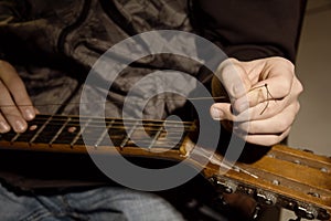 Close-up of a man with a guitar string is torn