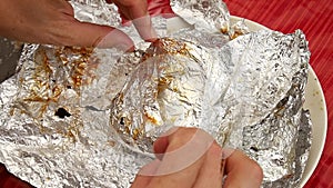 Close up of man hand with chrome long and sharp knife cutting roast pork ham