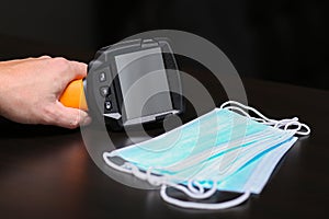 Close-up of a man hand-held holds a thermal imaging camera. Covid-19 temperature test without touching.