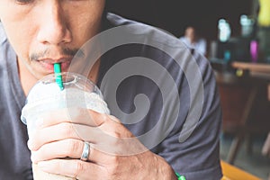 Close up of man hand holding a cup of iced coffee