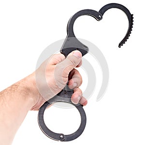 Close-up of man hand holding disclosed handcuffs, isolated on white background