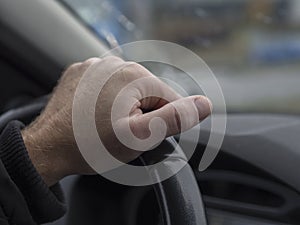 Close up man hand holding streering wheel view from inside of th