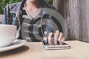 Close up of man hand holding touching mobile phone with blank copy space for your text message in cafe