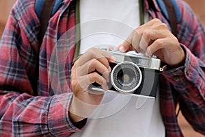 Close up of man hand holding vintage film camera, Tourist, traveller taking photo by vintage camera on vacation