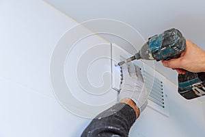 Close up man hand installing vent cover from ceiling