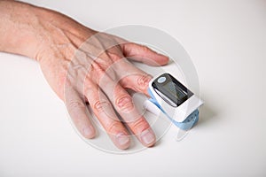 Close up of  a man hand measuring blood oxygen saturation with an oximeter