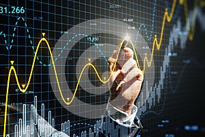 Close up of man hand with pen pointing at glowing candlestick forex chart on grid background