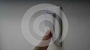 Close Up Man Hand Turning On the Light from a Wall Switch in Office Room