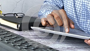 Close up of man hand use digital tablet at office desk