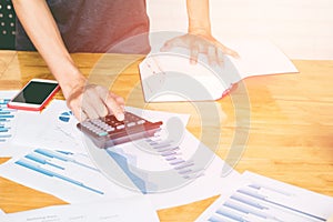 Close up man hand using calculator Calculating bonusOr other compensation to employees to increase productivity.