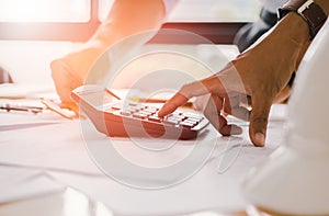 Close up man hand using calculator Calculating bonusOr other compensation to employees to increase productivity.Writing paper on