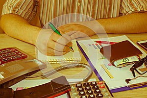 Close up Man hand using calculator and writing make note with calculate about cost at home office