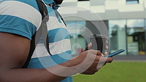 Close-up of a man hand using smartphone in the city. Online communication with friends. Typing chat message. Internet