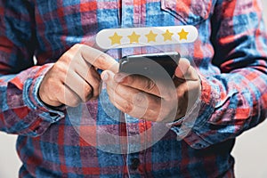 close up Man hand using smartphone with popup five star icon for feedback review satisfaction service, Customer service experience
