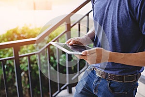 Close up of man hand using tablet while walking at outdoors. Technology and Lifestyles concept. Working people and Gadget theme.