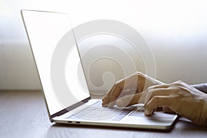 Close-up of man hand using and typing keyboard of laptop computer on office desk.