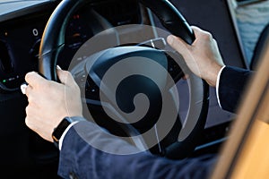 Close up of man hand on vehicle steering wheel as he is driving. Male driving a car in the highway, hands move on the
