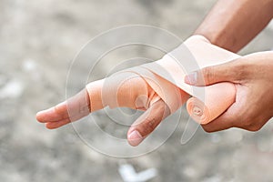 Close-up of a man hand wrapping elastic bandage. Wounded hand cover with bandage