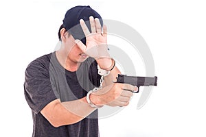 Close up man with handcuffs and gun on hands isolated on white