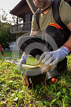 Close up of man hands on grass trimmer checking if machine is working properly