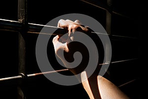 Close up Man hands are holding the cage door in dark room