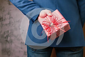 close up of man hands holding gift box behind his back