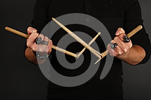 Man hands with broken drumsticks over black