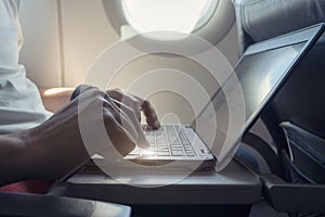 Close up, Man hands using computer laptop, working while sitting on the airplane