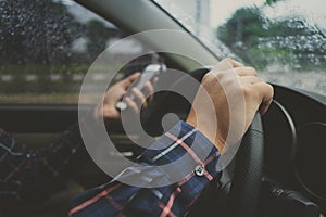 Close up of man hands using phone while driving a car, transportation and vehicle concept