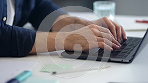 Close up man hands working laptop computer. Male professional typing computer