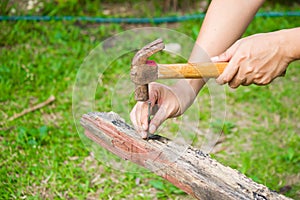 Close up of man hitting nail by hammer