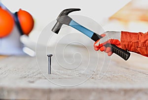 Close up of man hitting nail by hammer for construction