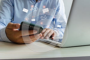 Close-up man holding a cell phone an icon email message. Marketing business sending information to customers or hacking online