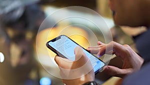 Close up of a man holding device and reading the text on the screen, modern technologies concept. Stock. A man in dark