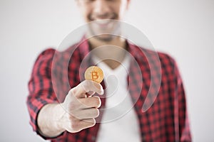 Close-up of man holding gold BitCoin - digital cryptocurrency