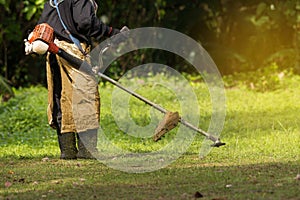 Close up of man holding grass trimmer. photo