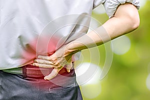 Close up of a man holding his back in pain