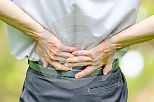 Close up of a man holding his back in pain