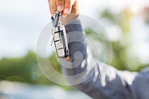 Close-up of man holding keys to new car. Copy space.
