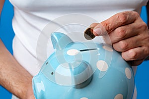 Close up of man holding piggy bank, saving money for investment