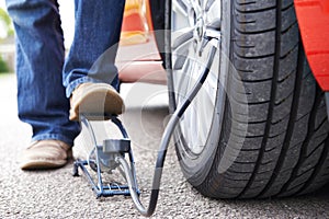 Close Up Of Man Inflating Car Tyre With Foot Pump