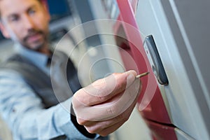 close up man inserting coin into vending machine