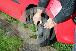 Close up of a man inspecting car tires or tyres.