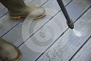 Close Up Of Man Jet Washing Patio Decking With Pressure Washer