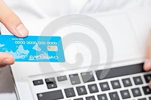 Close up of man with laptop computer and credit card at home