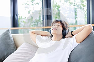 Close-up of man listen to music on a comfortable couch at home. Time to relax and leisure activities